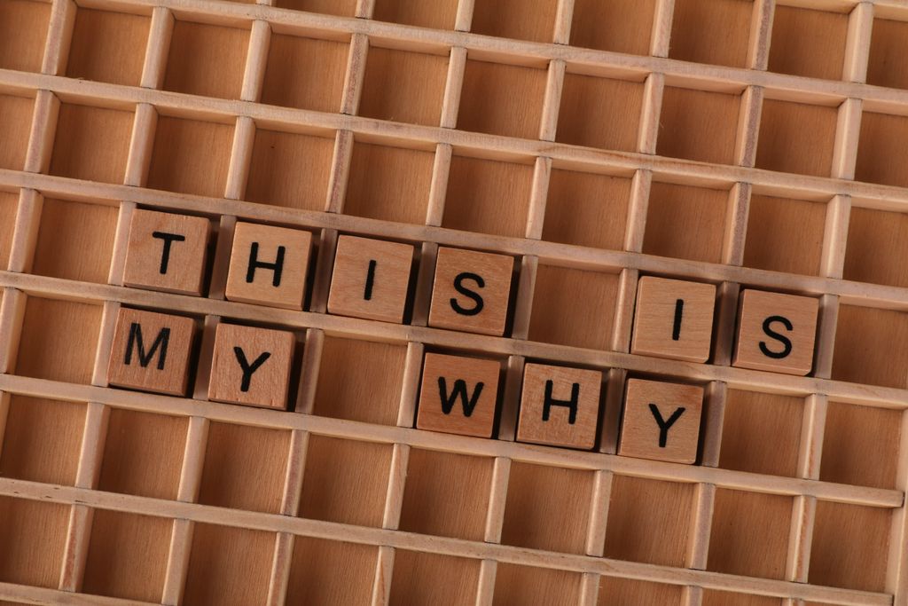 Scrabble tiles arranged to spell 'This Is My Why' on a wooden grid. Perfect for motivation and introspection themes.